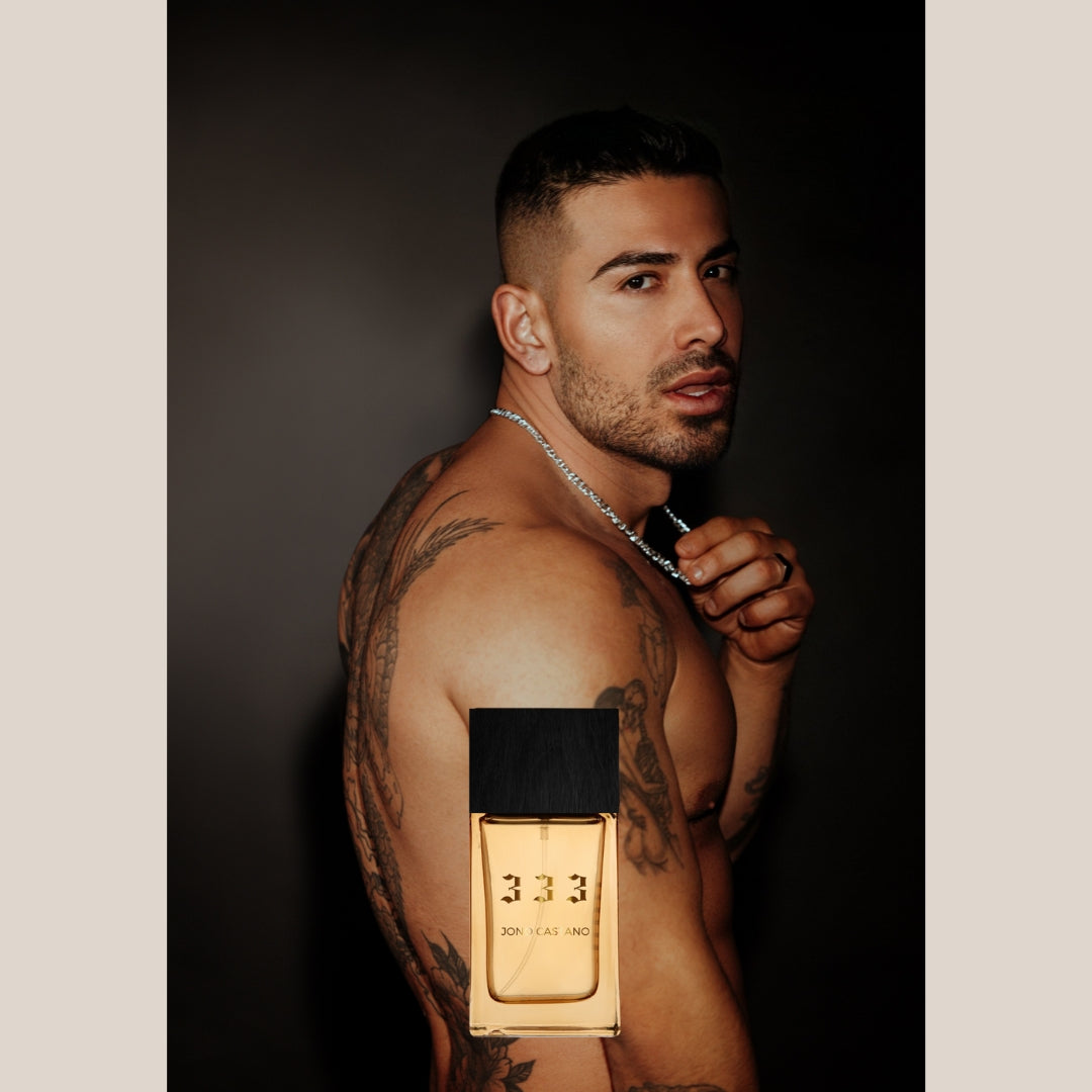 333 by Jono Castano fragrance bottle shown in front of a tattooed person wearing a chain necklace.